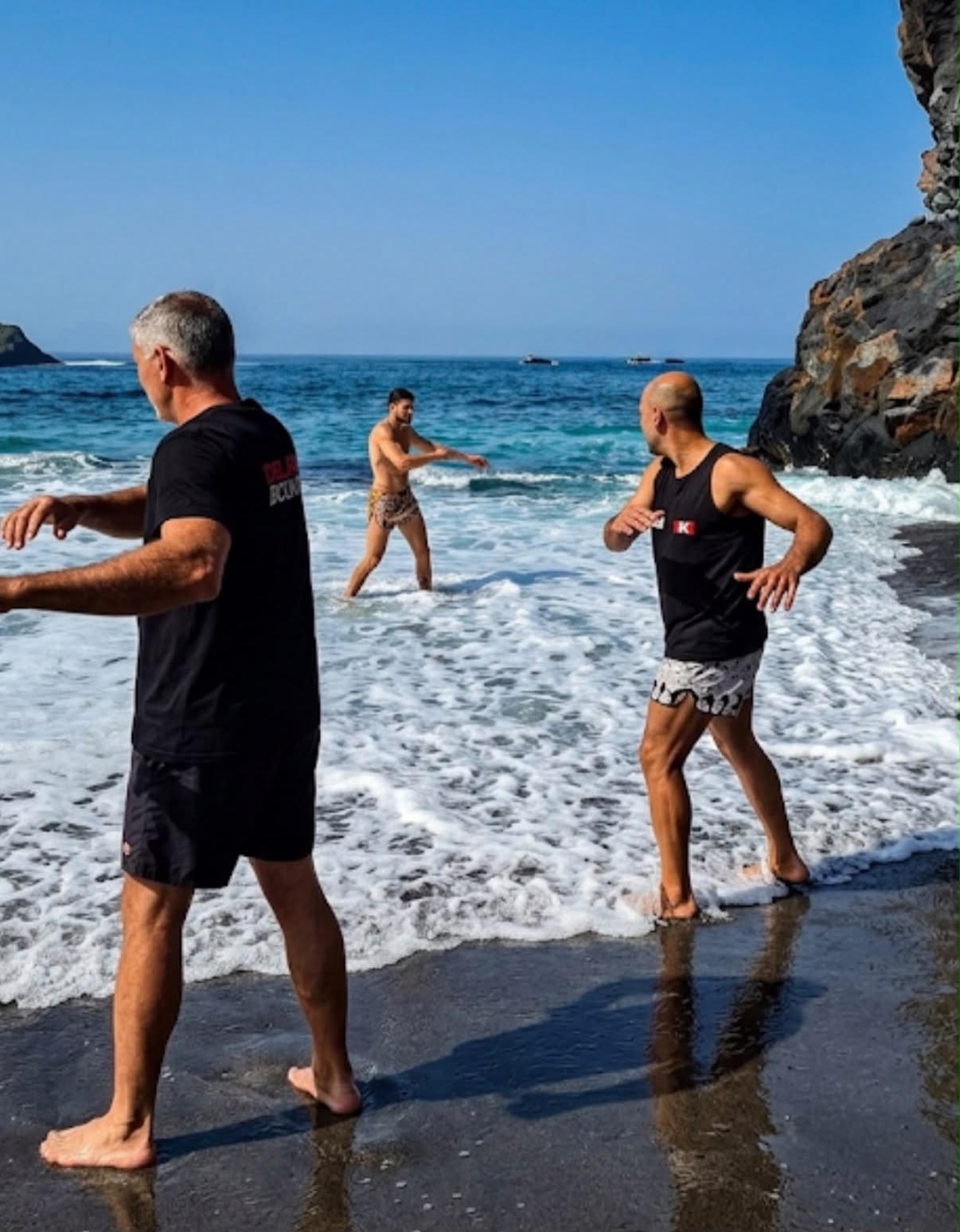 Shadowboxing in surf on volcanic beach